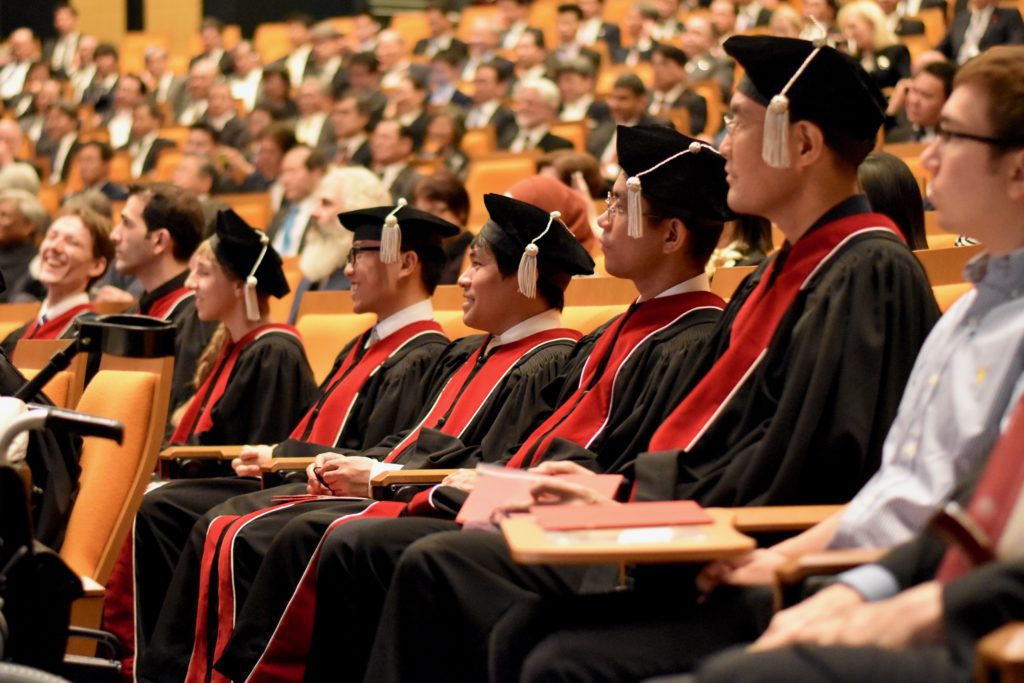 College Rankings: Best Colleges in the US & Best Universities in the World image; a photo of students graduating from college wearing black and red gowns; collegeadvisor.com